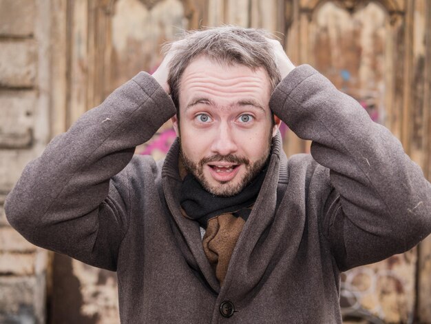 Foto ritratto di un uomo adulto con la mano nei capelli in piedi all'aperto