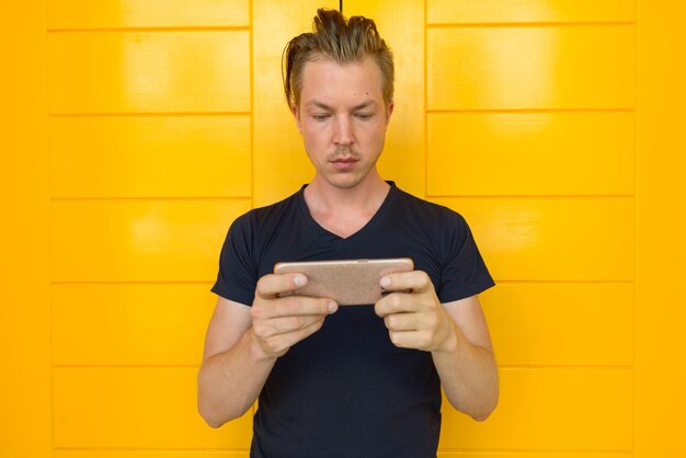 Photo portrait of mid adult woman standing against yellow wall