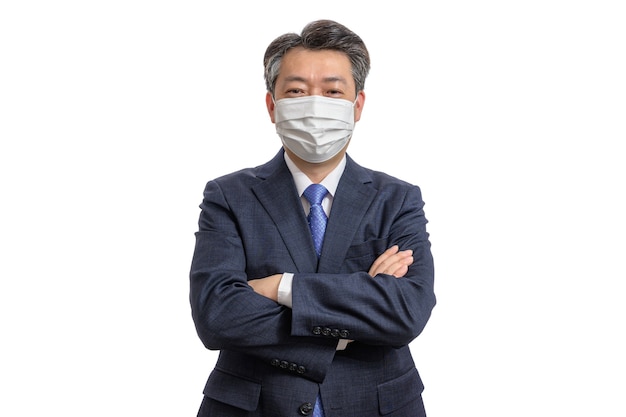 Portrait of a middle-aged Asian businessman wearing a white face mask. 
