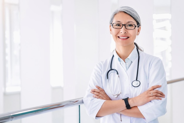 Portrait of middle aged asian female doctor standing in hospital corridor