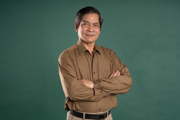 portrait of middle aged asian man posing on blue background