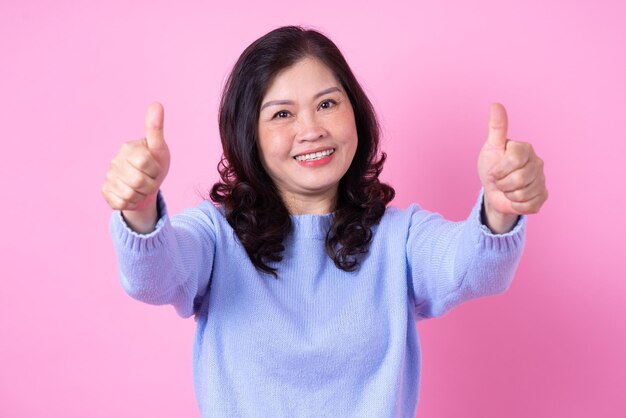 Portrait of middle aged Asian woman on pink background