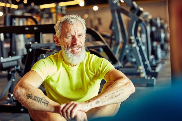 Portrait of a middle aged man discussing workout plan with fitness instructor while sitting