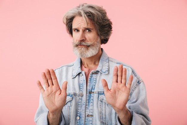 Portrait of a middle aged man wearing casual outfit standing isolated, showing disbelief