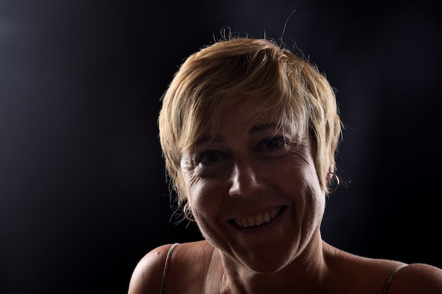 Portrait of a middle aged woman on black