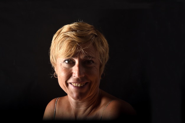 Portrait of a middle aged woman on black