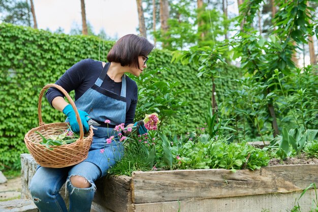 裏庭の庭の花壇の世話をする中年の女性の肖像画