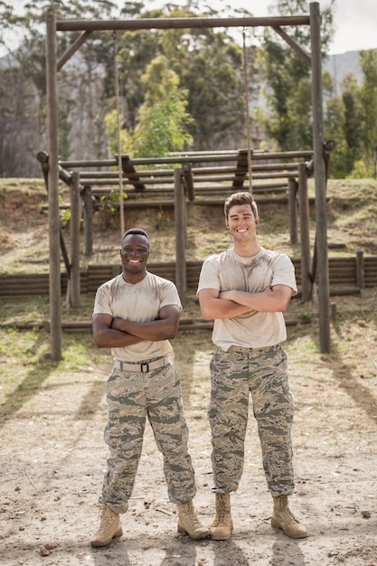 Portrait of military man standing with arms crossed during obstacle course in boot camp