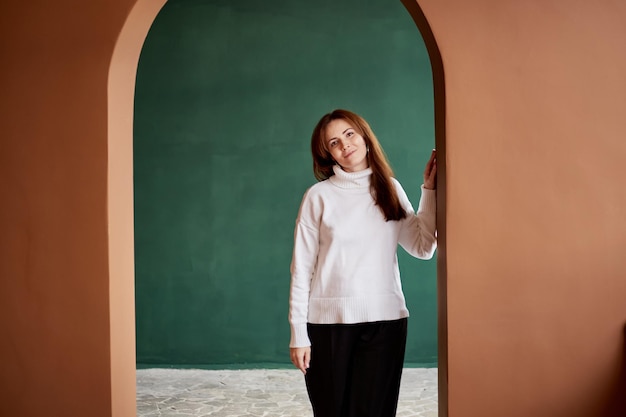 Portrait of millennial female wearing in warm sweater with natural freckles