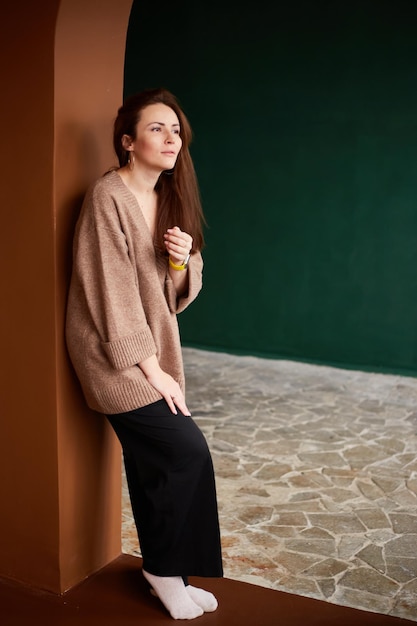 Portrait of millennial female wearing in warm sweater with natural freckles