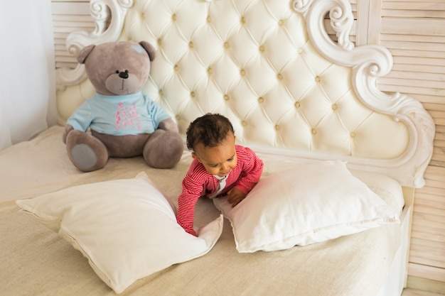 Portrait of mixed race kid at home playing with teddy bear