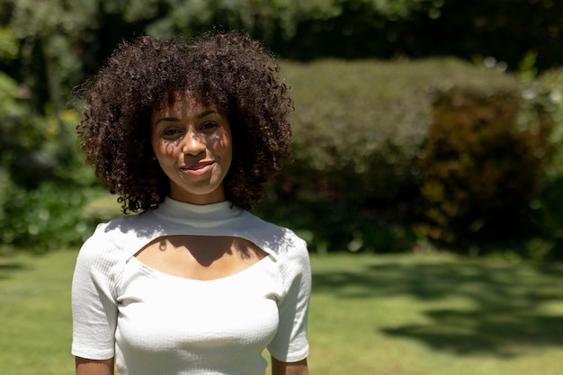 Portrait of a mixed race woman smiling at camera in the garden on sunny day