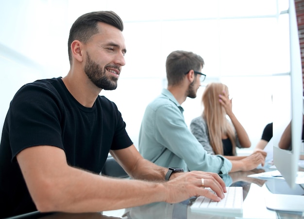 Portrait of a modern business team working at new project during meeting and looking at laptop