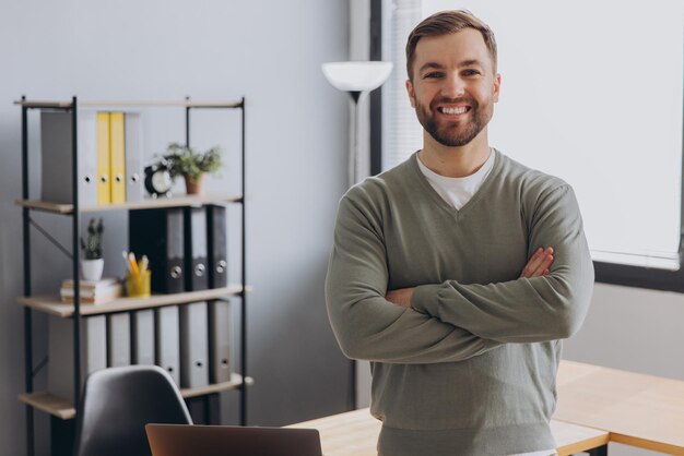 Photo portrait of a modern businessman man in a gray shirt smiling with healthy teeth in the office