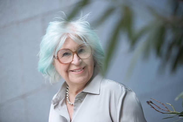 Portrait of modern older woman looking at camera with smile outdoors