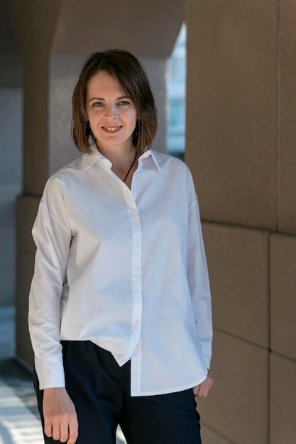 Portrait of modern smiling woman in business casual Girl is wears white shirt and trousers