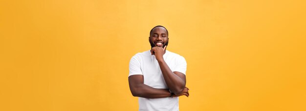 Portrait of a modern young black man smiling with arms crossed on isolated yellow background person