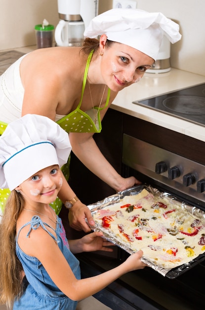 Portrait of mom and kid with pizza