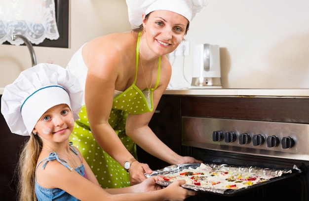 Portrait of mom and kid with pizza