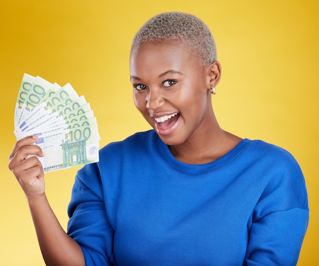 Portrait money winner and black woman with euros in studio isolated on a yellow background Financial freedom wealth and face of happy excited and rich female with cash after winning lottery prize