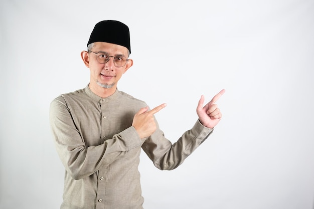 Portrait of Moslem Asian Man pointing hands and finger to the side explain something