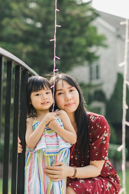 Photo portrait of mother and daughter by railings