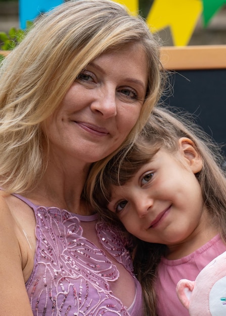 Portrait of mother and daughter Closeup Mom tenderly hugs her little girl