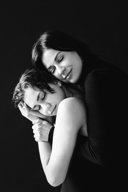 Portrait of mother and daughter hugging black and white