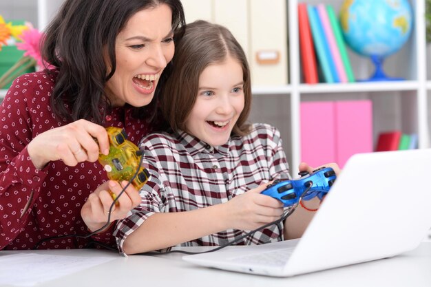 Portrait of mother and daughter playing computer game