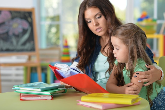 Portrait of mother and daughter reading books