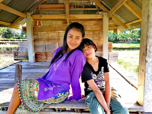 Photo portrait of mother and daughter sitting in wooden gazebo