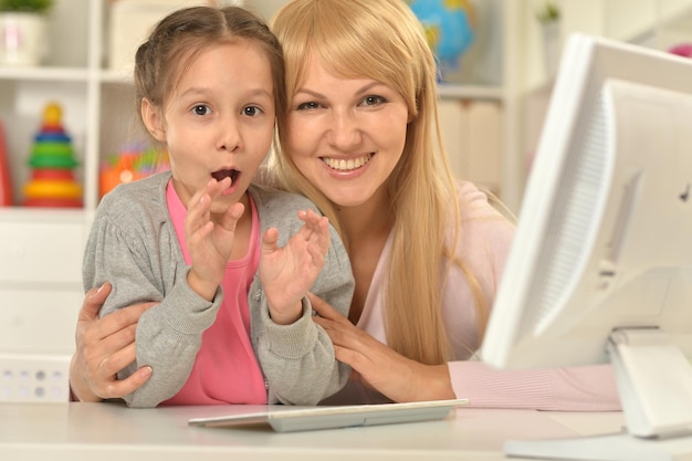 Portrait of mother and daughter using computer