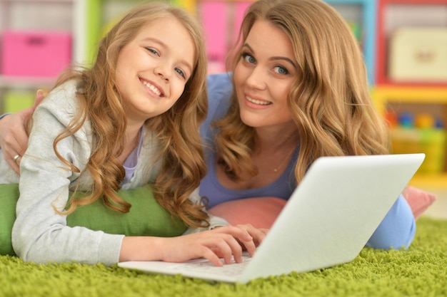 Portrait of mother and daughter using laptop