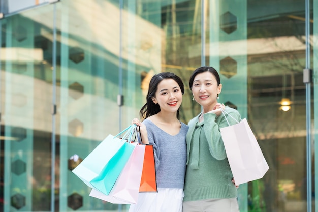 Portrait of a mother and daughter walking with shopping bags