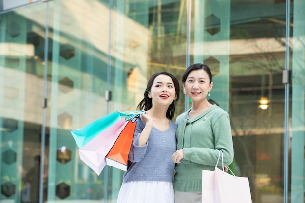 Portrait of a mother and daughter walking with shopping bags