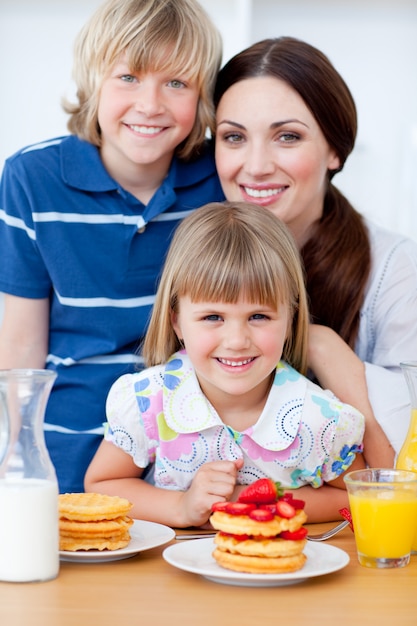 Portrait of a mother and her children having breakfast