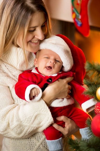 Portrait of mother posing with cute baby Santa