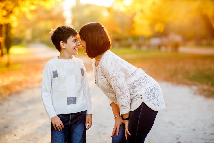 Photo portrait of a mother and son at autumn park