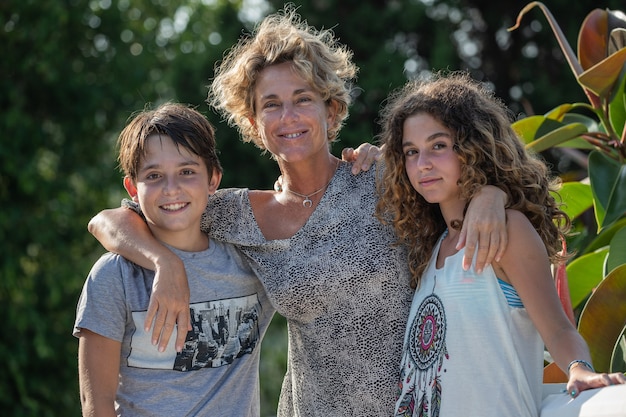 Portrait of mother, son and daughter in a garden during their holidays