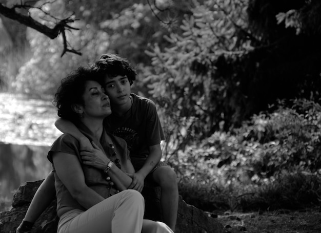 Photo portrait of mother and son sitting in forest