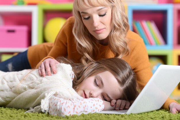 Portrait of mother waking up her little daughter