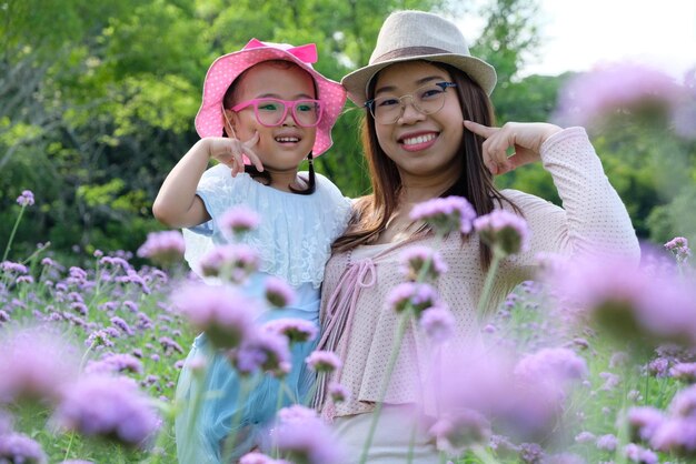 Photo portrait of mother with daughter standing by flowering plants