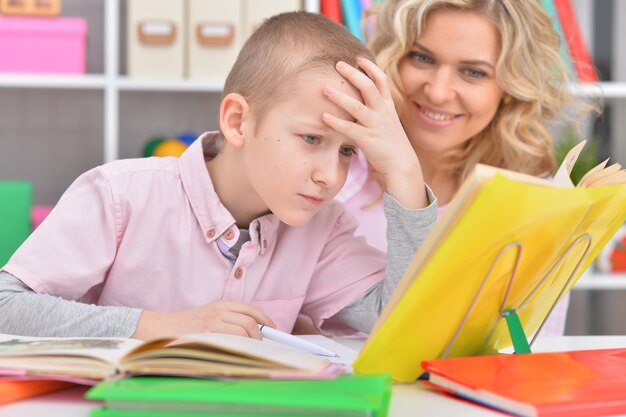 Portrait of mother with her son doing homework at home