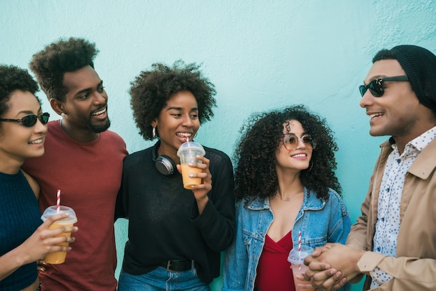 Ritratto di gruppo multietnico di amici divertendosi insieme e godersi un buon tempo bevendo succo di frutta fresca.