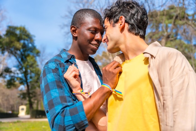 Portrait of multiethnic gay male couple on a romantic walk in the park lgbt concept