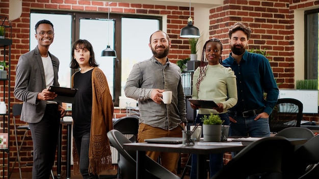 Photo portrait of multiethnic group doing teamwork on presentation, planning research project to create business partnership. people working on professional report with data. tripod shot.