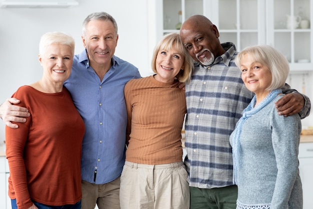 Photo portrait of multiethnic group of senior people friends posing together