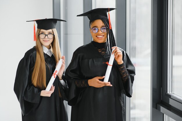 Portrait of multiracial graduates holding diploma