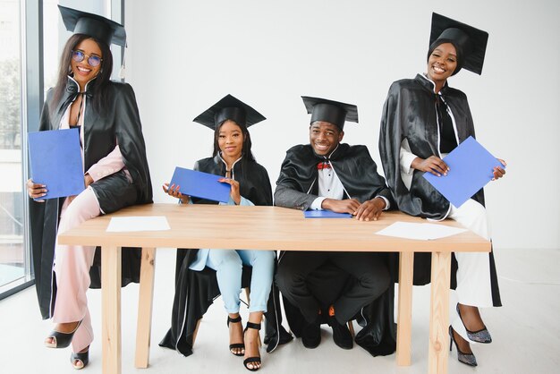 Portrait of multiracial graduates holding diploma