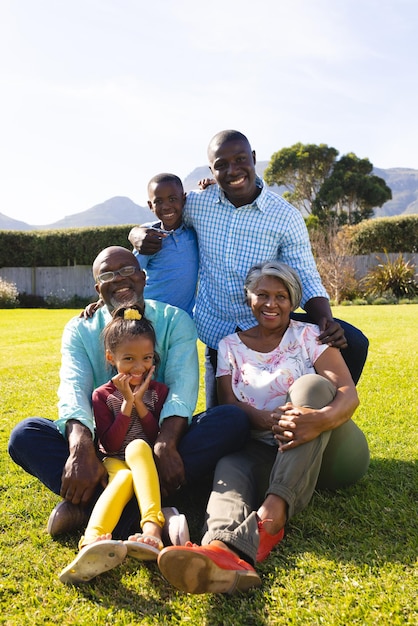 Portrait of multiracial multigeneration family enjoying leisure time on field against clear sky